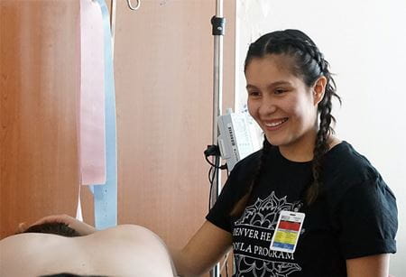 A member of the Denver Health Doula Program stands next to a patient